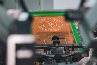 Trabalhador a realizar serigrafia em camisolas num atelier em Maputo